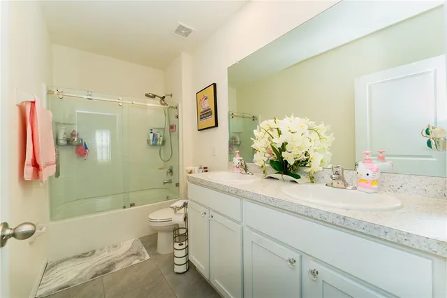 a bathroom with a double vanity sink toilet and shower