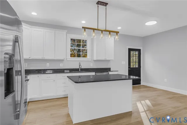 a kitchen with stainless steel appliances granite countertop a sink and a refrigerator