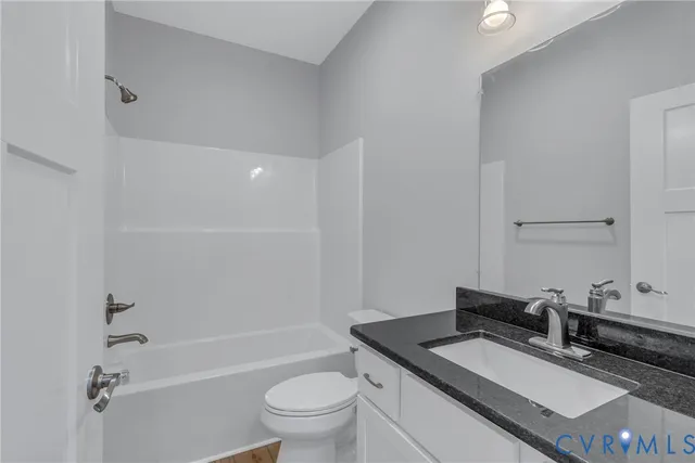a bathroom with a granite countertop sink a toilet and shower