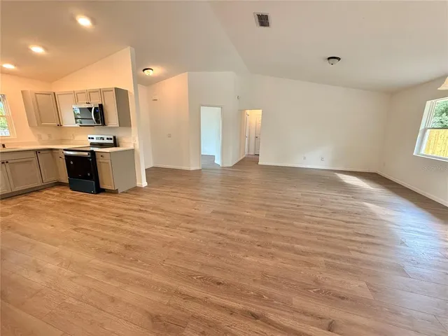 a view of kitchen with kitchen island granite countertop a sink and cabinets