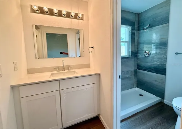 a bathroom with a double vanity sink mirror and shower