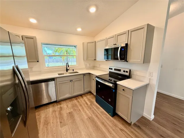 a kitchen with a sink stove and microwave
