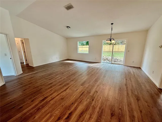 a view of empty room with wooden floor and window