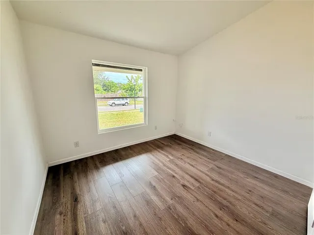 an empty room with wooden floor and a window