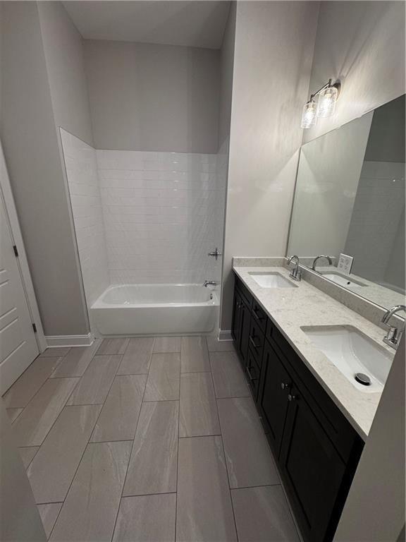 1777 Temple Avenue, Unit O Atlanta, GA 30337 - Photo 13 of 22 a bathroom with a double vanity sink a mirror and a bathtub