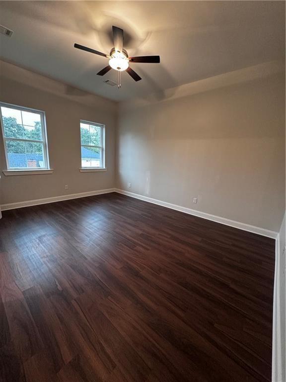 1777 Temple Avenue, Unit O Atlanta, GA 30337 - Photo 19 of 22 an empty room with wooden floor ceiling fan and windows
