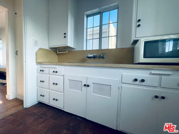 a kitchen with granite countertop white cabinets and sink