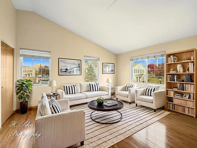 a living room with furniture and a large window with wooden floor