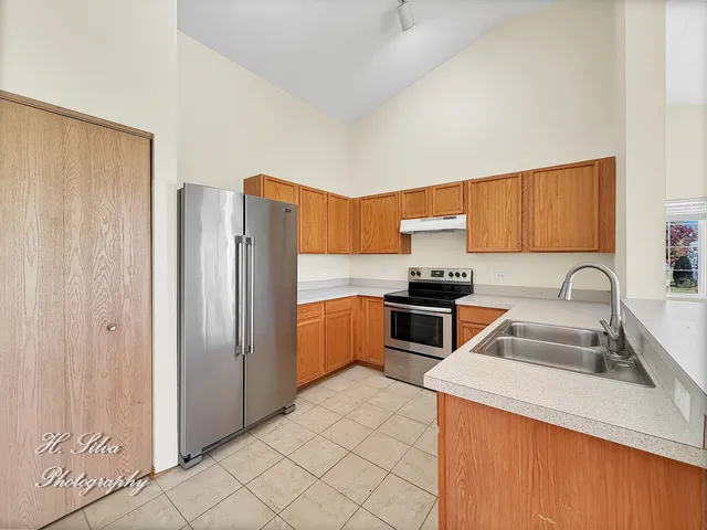 a kitchen with granite countertop a refrigerator and a sink