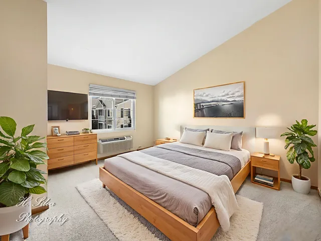 a bedroom with a bed a couch and a flat screen tv