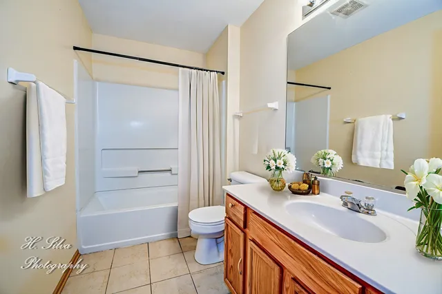 a bathroom with a granite countertop sink a toilet and shower
