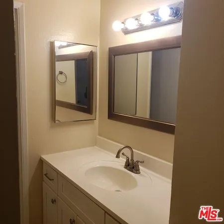 a bathroom with a sink vanity and mirror