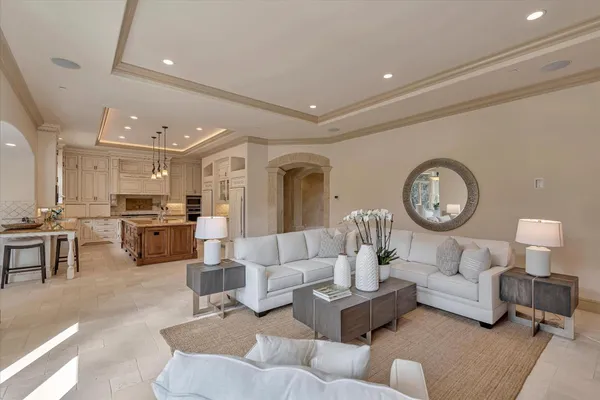 a dining room with furniture large windows and a chandelier