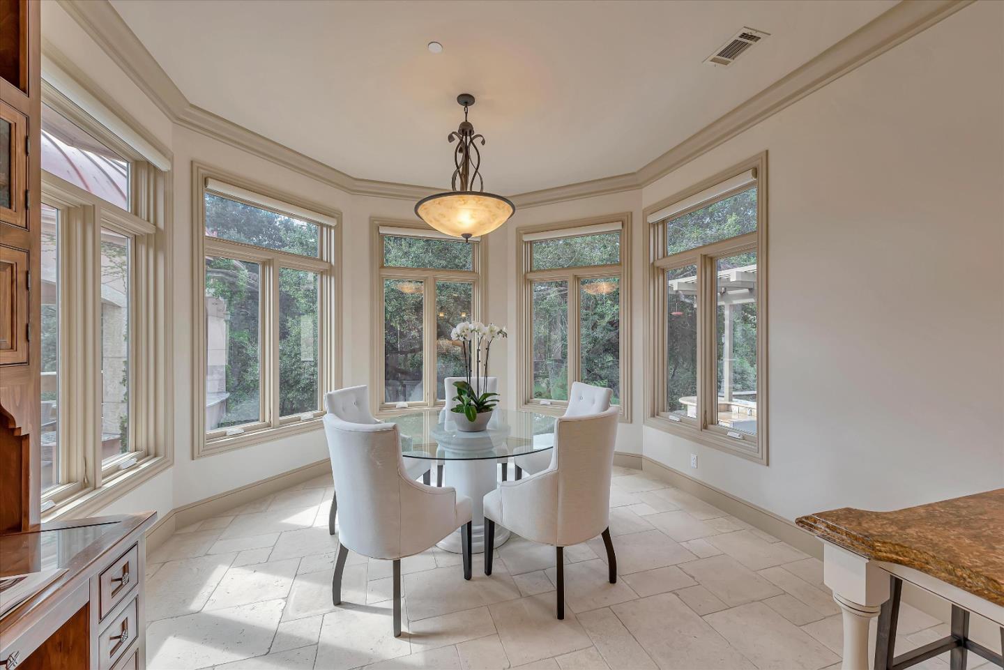 28025 Natoma Road Los Altos Hills, CA 94022 - Photo 25 of 44 a dining room with furniture large windows and a chandelier