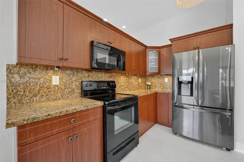 a kitchen with stainless steel appliances granite countertop a refrigerator stove top oven and sink