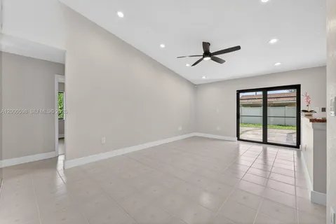 an empty room with windows and ceiling fan