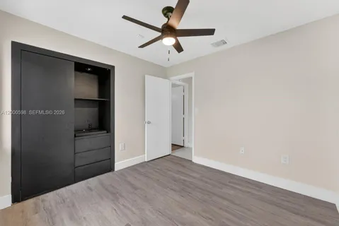 a view of empty room with wooden floor and ceiling fan