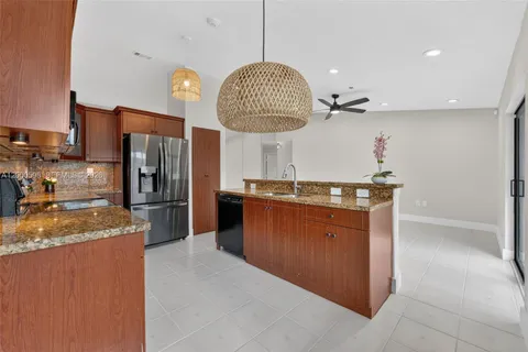 a kitchen with stainless steel appliances granite countertop a sink a stove and a refrigerator