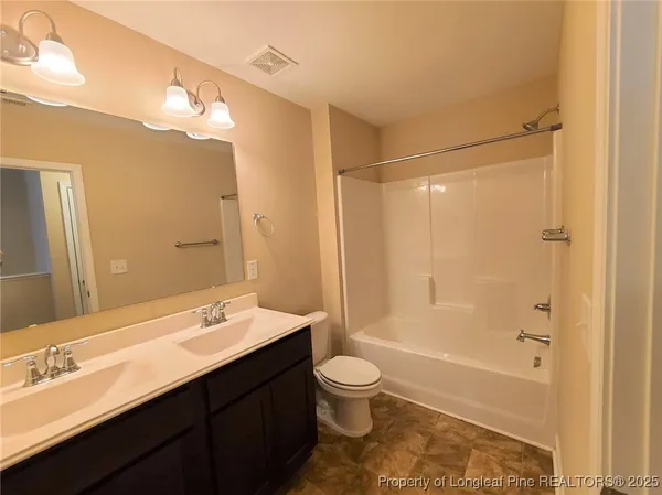 a bathroom with a double vanity sink toilet mirror and bathtub