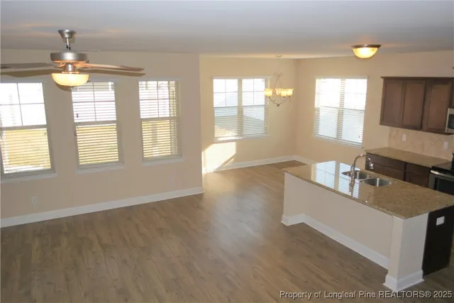 a view of a kitchen with a sink dishwasher and wooden cabinets