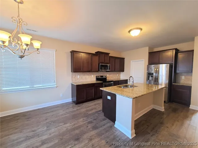 a large kitchen with a stove top oven a sink dishwasher and a refrigerator