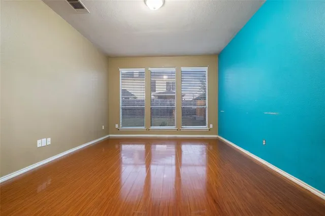 a view of a room with wooden floor and windows