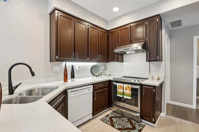 a kitchen with granite countertop a sink stainless steel appliances and cabinets