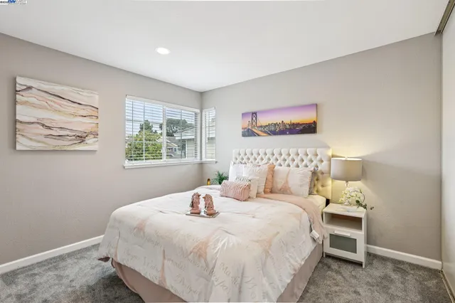 a large bed sitting in a bedroom next to a window