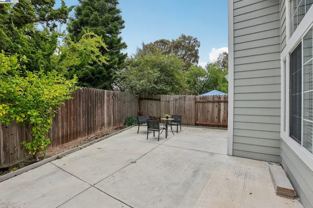 a view of backyard with table and chairs and wooden fence