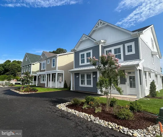 a front view of a house with a garden and plants