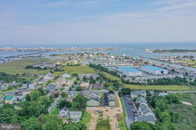 an aerial view of a city with lots of residential buildings and mountain view in back