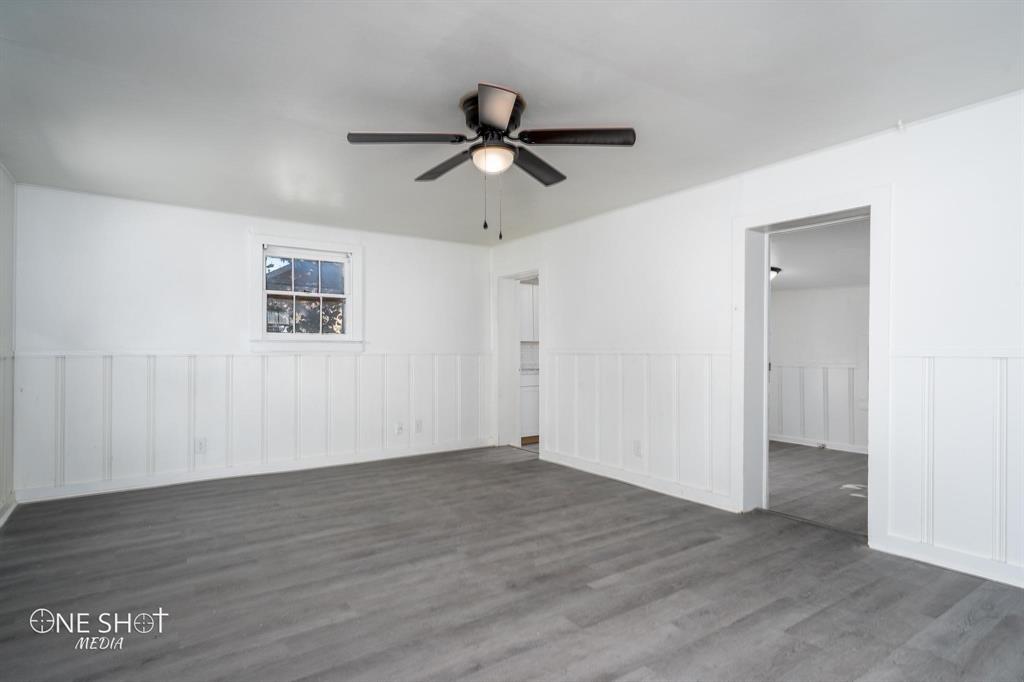 1909 Highland Avenue Abilene, TX 79605 - Photo 14 of 23 an empty room with wooden floor ceiling fan and windows