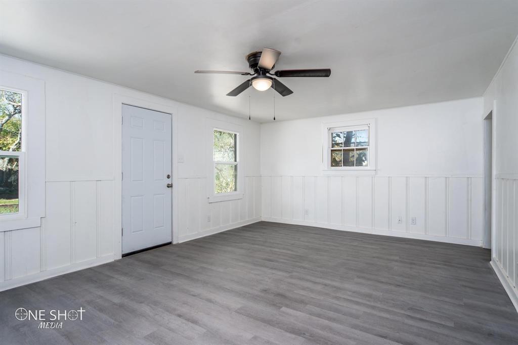 1909 Highland Avenue Abilene, TX 79605 - Photo 15 of 23 an empty room with wooden floor ceiling fan and windows