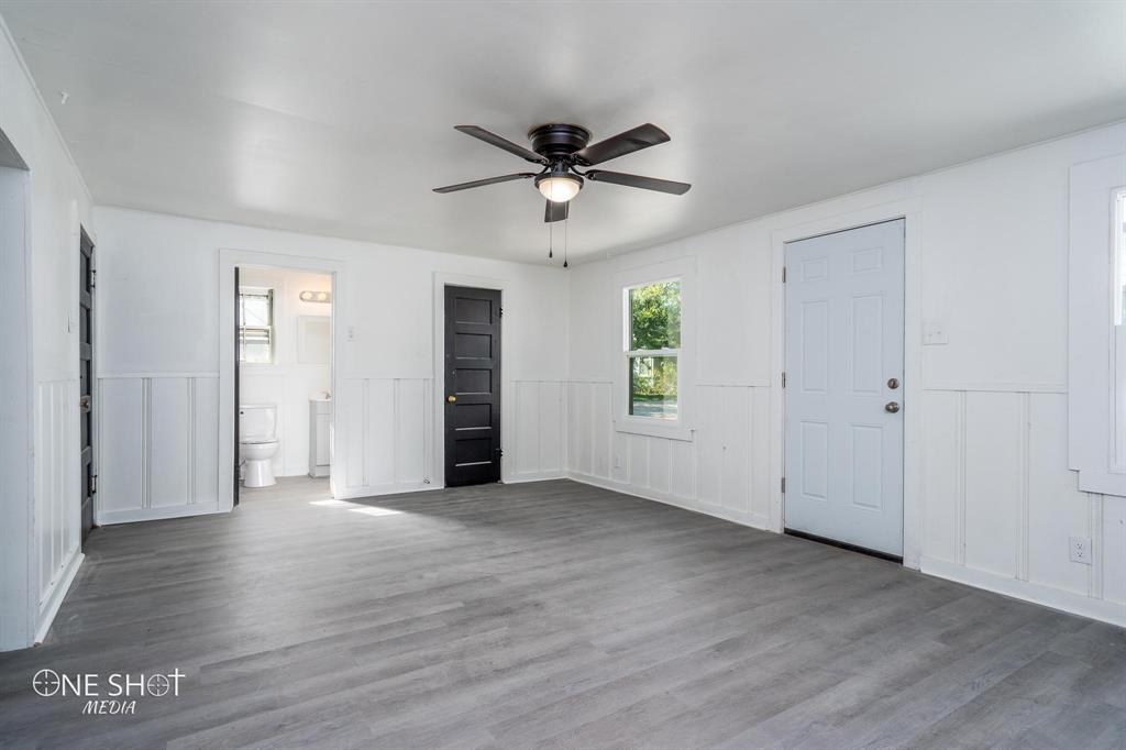 1909 Highland Avenue Abilene, TX 79605 - Photo 16 of 23 an empty room with wooden floor a ceiling fan and windows