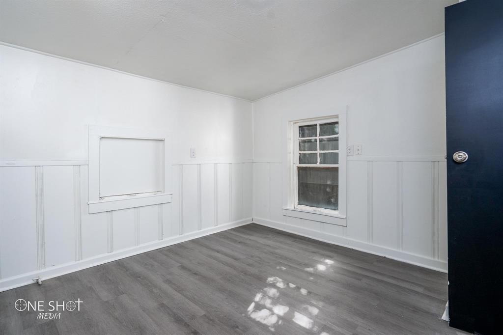 1909 Highland Avenue Abilene, TX 79605 - Photo 19 of 23 an empty room with wooden floor and windows