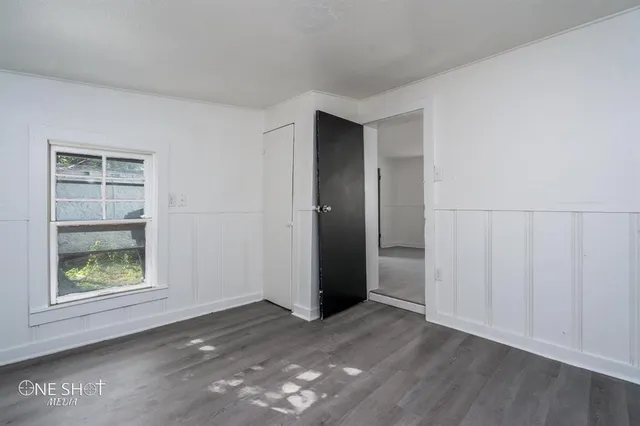an empty room with windows and closet
