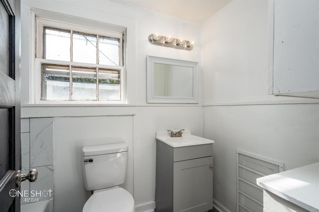 1909 Highland Avenue Abilene, TX 79605 - Photo 22 of 23 a bathroom with a toilet sink and mirror