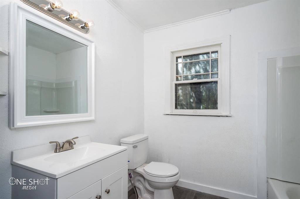 1909 Highland Avenue Abilene, TX 79605 - Photo 8 of 23 a bathroom with a toilet sink vanity and mirror