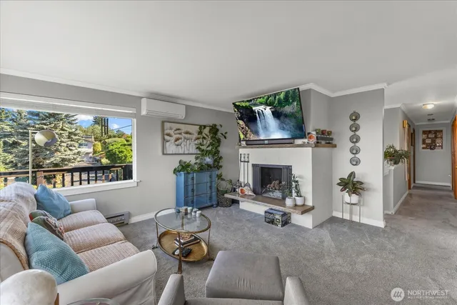 a living room with furniture a fireplace and a large window