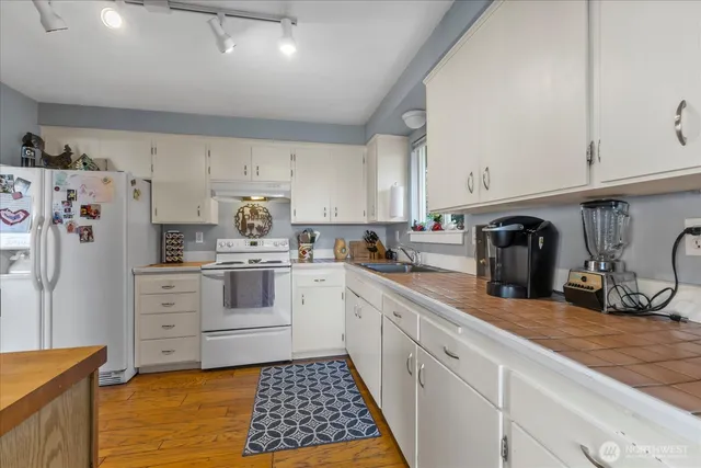 a kitchen with stainless steel appliances white cabinets and a refrigerator