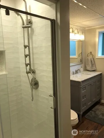 a bathroom with a granite countertop sink a mirror and shower