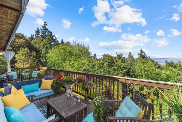 a view of a balcony with wooden floor and outdoor seating