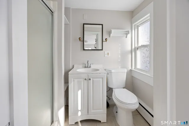 a white toilet sitting next to a bathroom sink