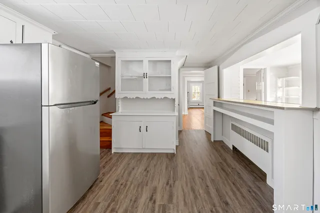 a kitchen with a refrigerator a sink and dishwasher with wooden floor