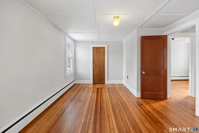 a view of an empty room with wooden floor