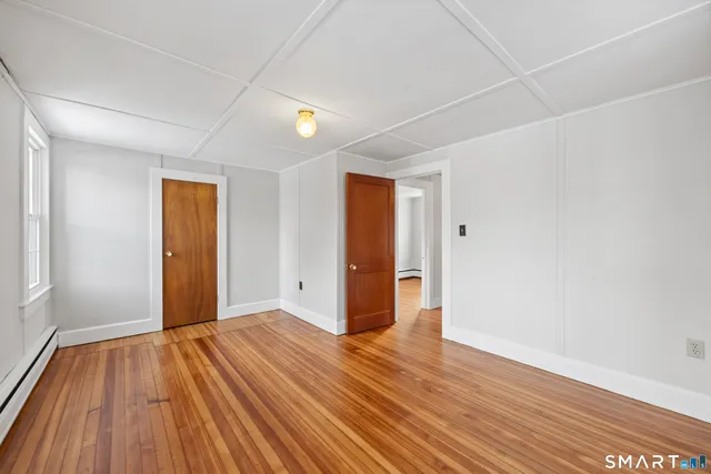 a view of an empty room with wooden floor
