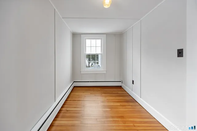 a view of a room with wooden floor and window