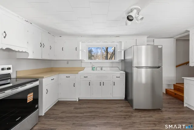 a kitchen with a refrigerator stove and white cabinets
