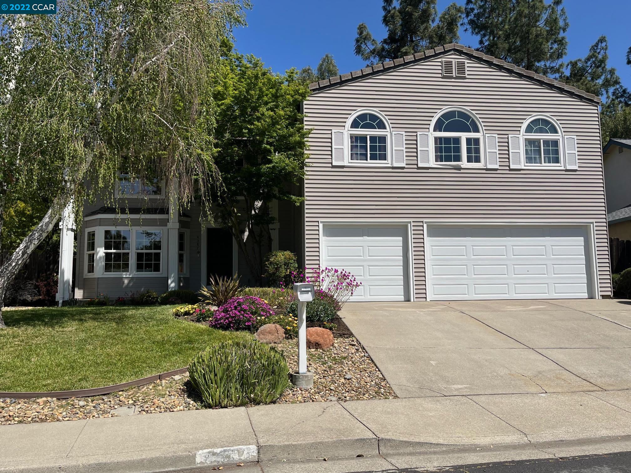 a front view of a house with a yard and garage