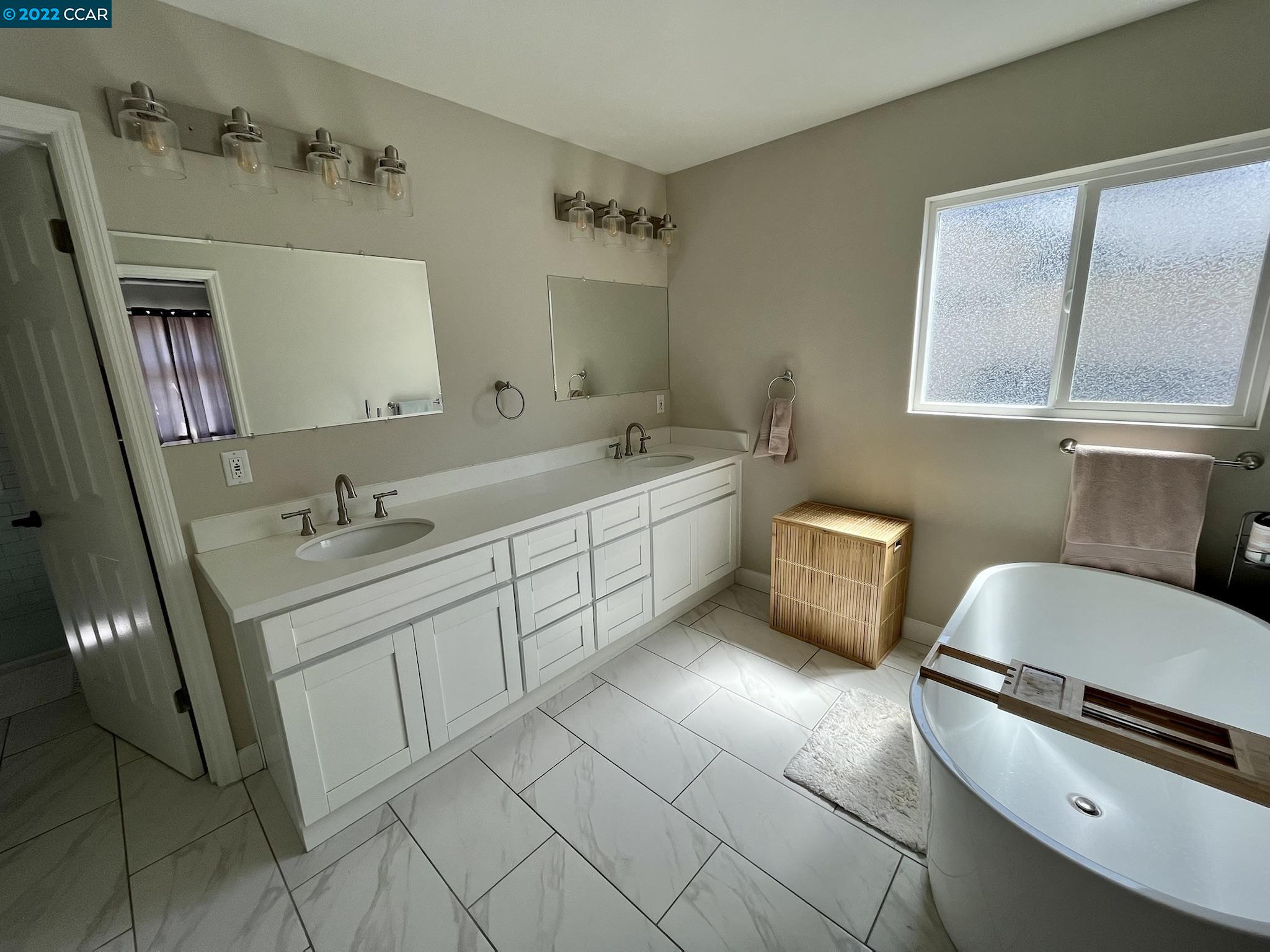 4387 Fallbrook Road Concord, CA 94521 - Photo 12 of 26 a spacious bathroom with a double vanity sink a mirror and a toilet